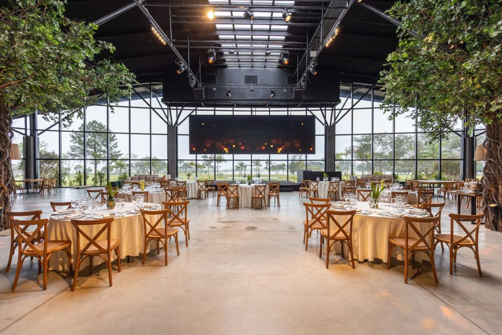 Spacious and elegant indoor venue with round tables set for a banquet or celebration.
