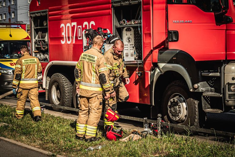 Firefighters prepare equipment beside a fire truck in Wrocław, Poland.