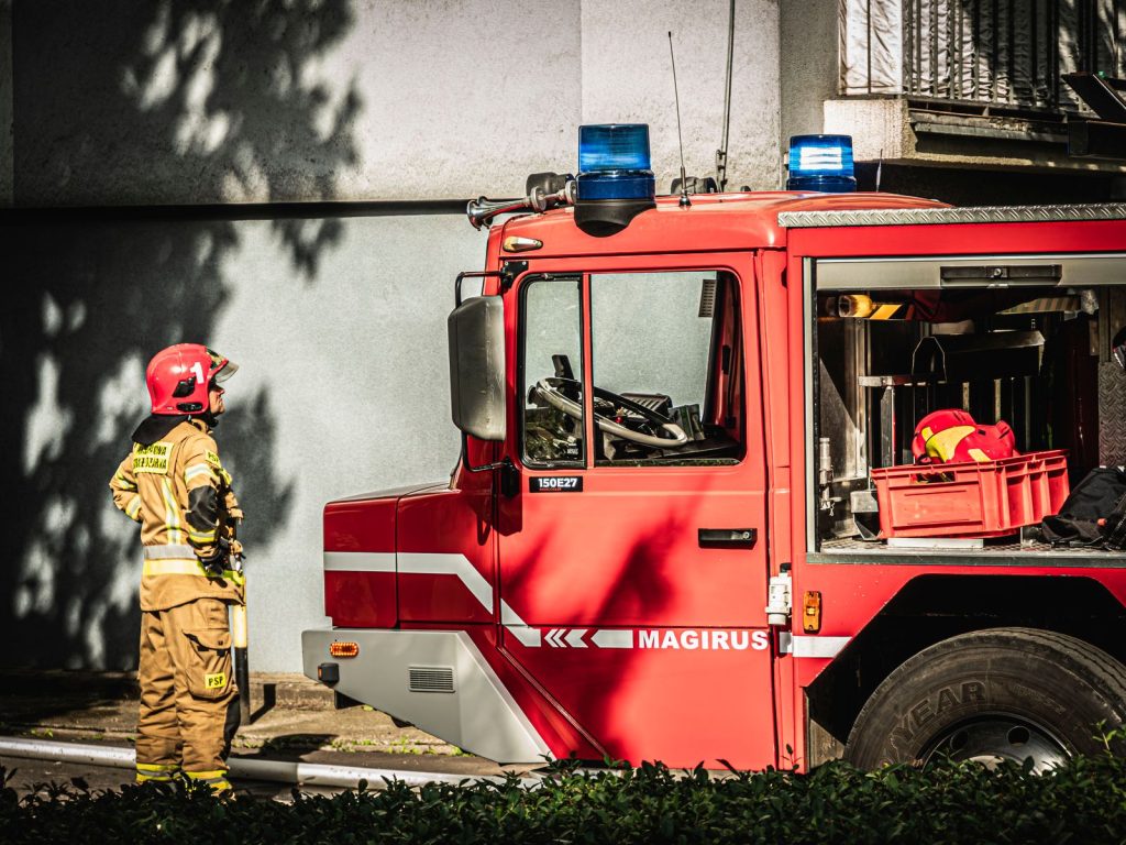 Firefighter standing beside a Magirus fire engine in Wrocław, Poland.
