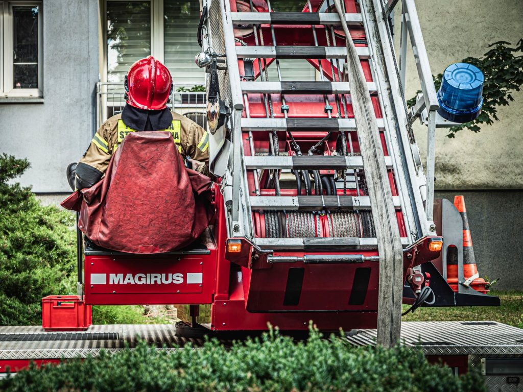 Firefighter operating ladder truck in Wrocław, showcasing emergency response and fire safety equipment.