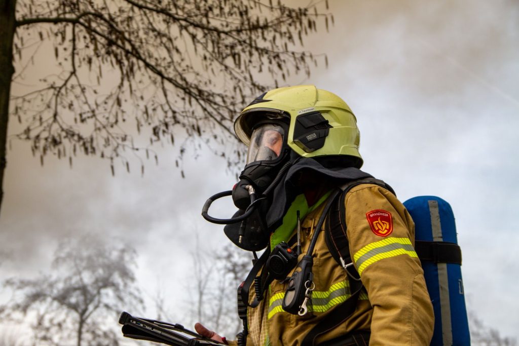 Firefighter in protective gear and gas mask ready to tackle an outdoor emergency in Ermelo, Netherlands.