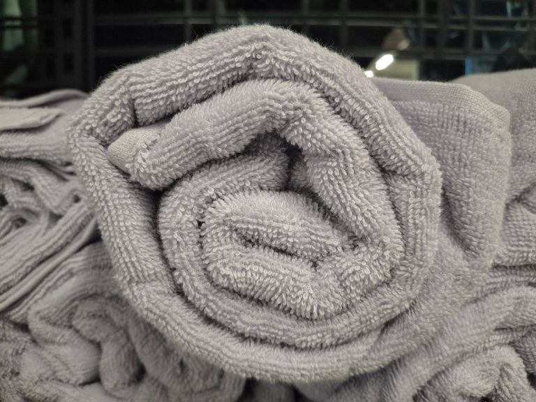 Rolled gray cotton towels showcasing texture and plush softness, perfect for bathrooms and laundry rooms.