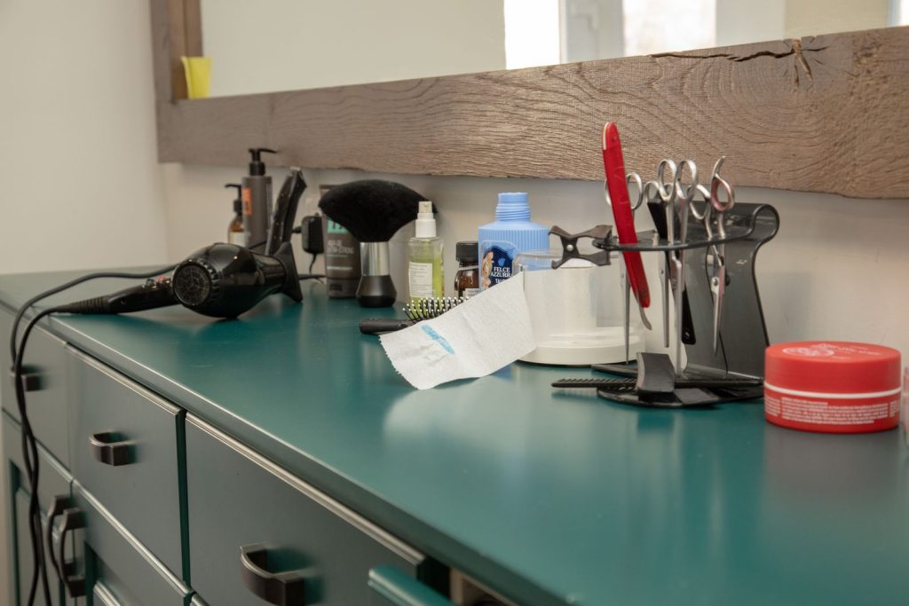 A well-organized salon workspace featuring essential hair styling tools on a cabinet.