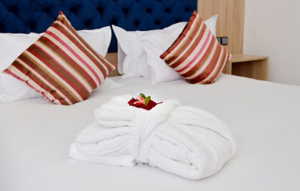 Cozy hotel room featuring plush pillows and neatly folded towels.