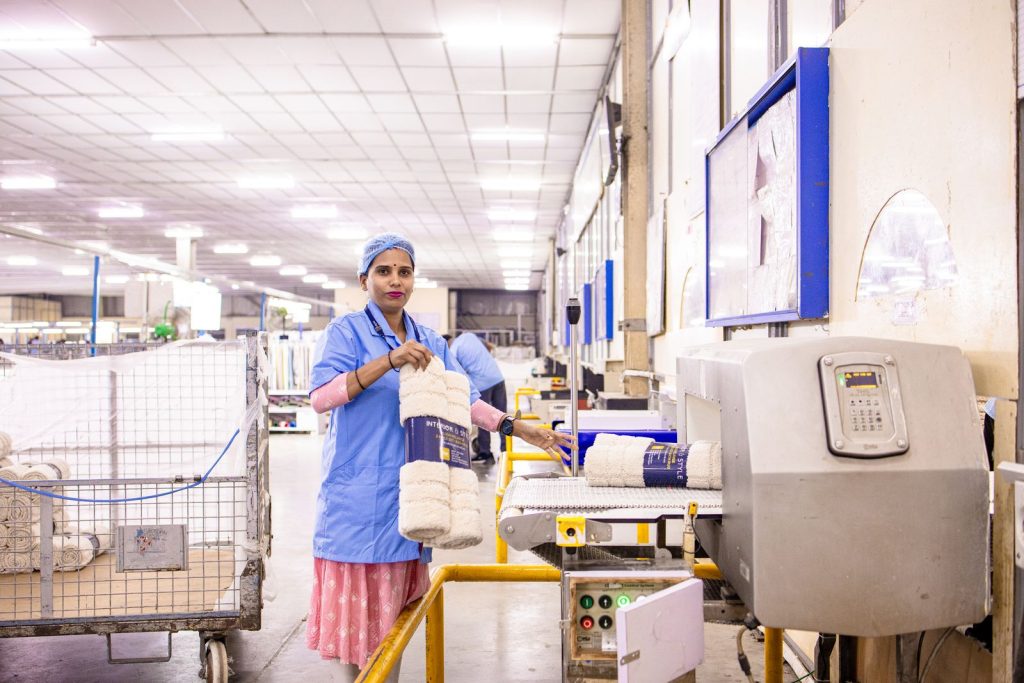 Female textile worker organizing products in a factory setting.