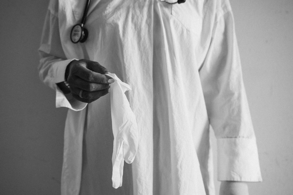A monochrome photo of a doctor holding a glove, symbolizing healthcare and professionalism.