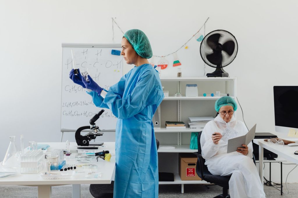 Researchers work in a laboratory analyzing samples, featuring vials and scientific equipment.