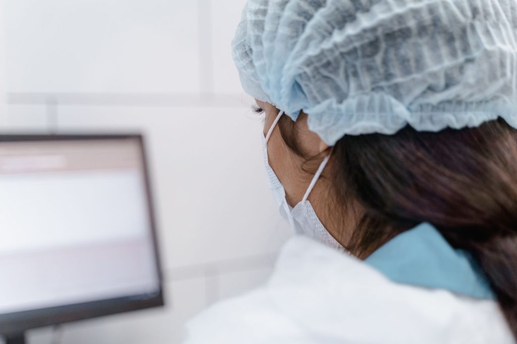 A lab technician wearing protective gear works on data analysis in a modern laboratory environment.