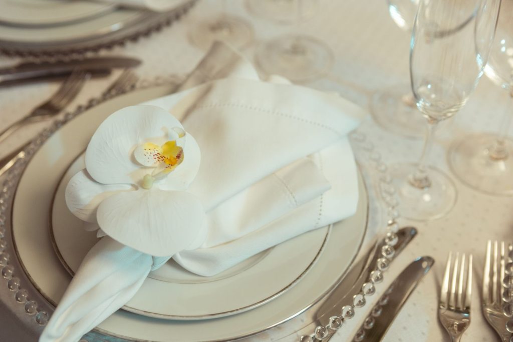 Chic table arrangement featuring white orchid and porcelain plates for a sophisticated dining experience.