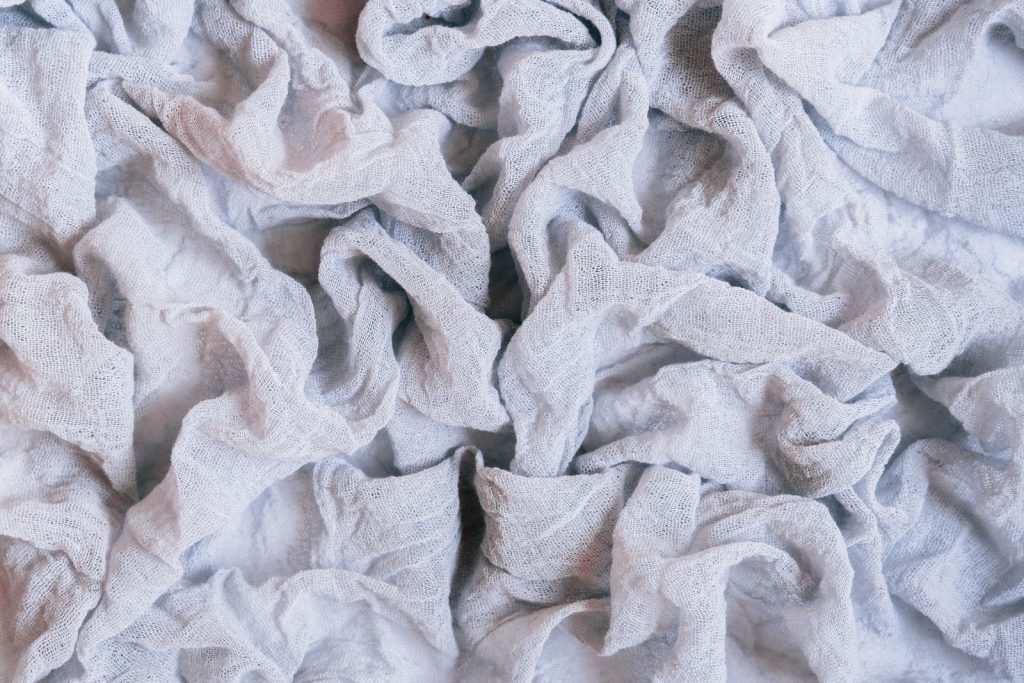 Detailed shot of textured and crumpled white fabric, perfect for backgrounds.