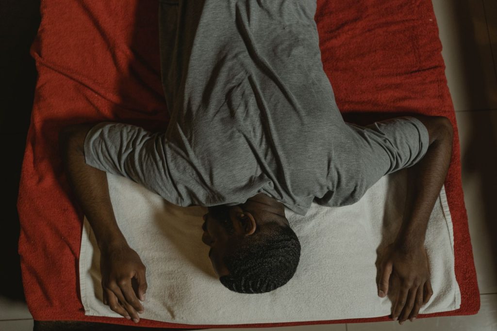 Top view of a man relaxing on a massage table, experiencing tranquility and wellness indoors.