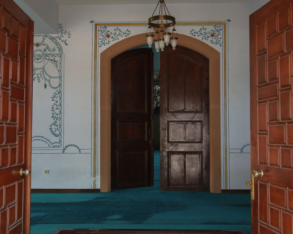 A beautifully decorated room with open double wooden doors in a traditional Turkish setting.