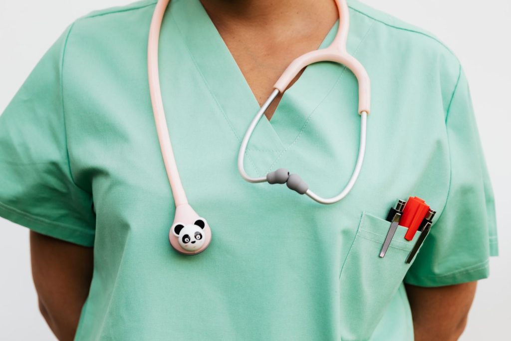 Close-up of a medical professional wearing scrub suit and panda-themed stethoscope