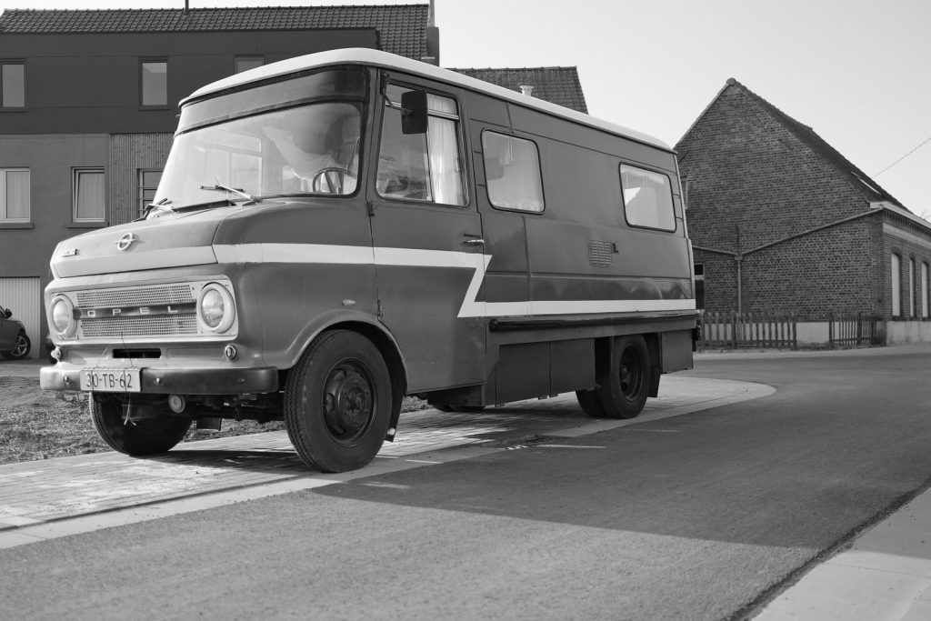 Classic Opel van parked on street, showcasing retro automotive design in monochrome.