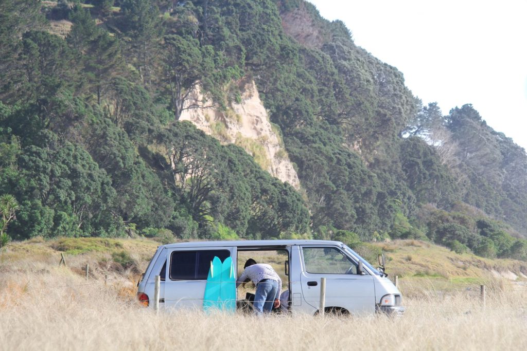 Explorer van parked by a lush forest under a sunny clear sky, perfect for a nature expedition.