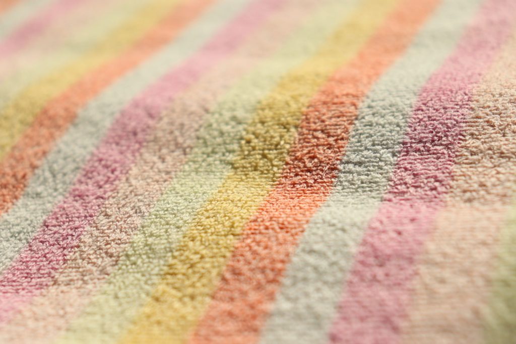 Close-up of a soft pastel striped fabric texture, ideal for design backgrounds.