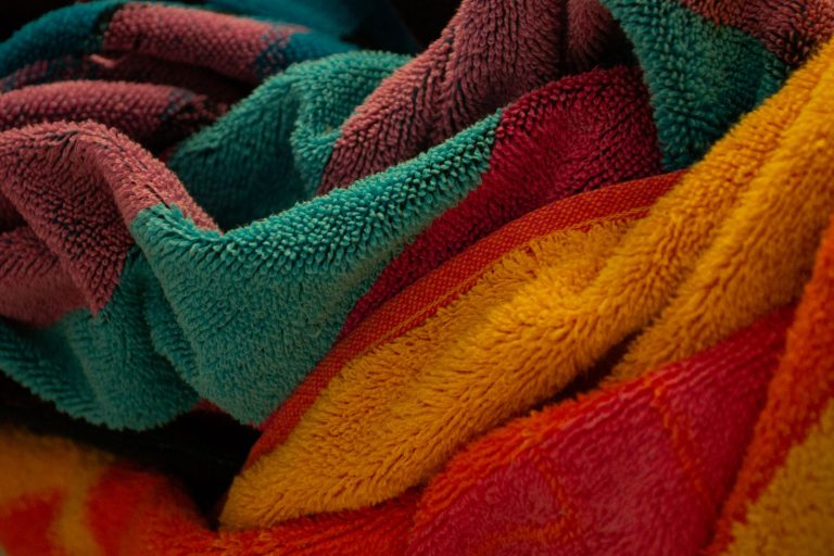 Close-up of colorful, soft textured towels with vivid hues and folds.