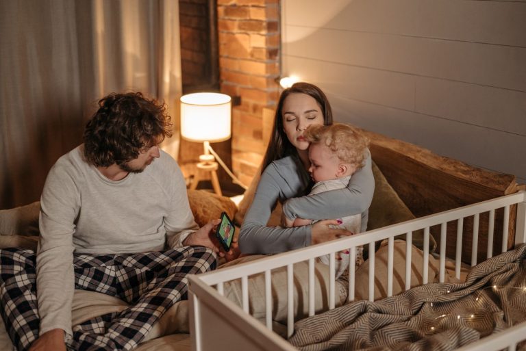 A family enjoys a quiet evening in their cozy bedroom, embracing warmth and love.