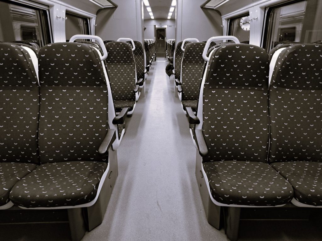 Interior view of empty train with patterned seats, ideal for travel themes.