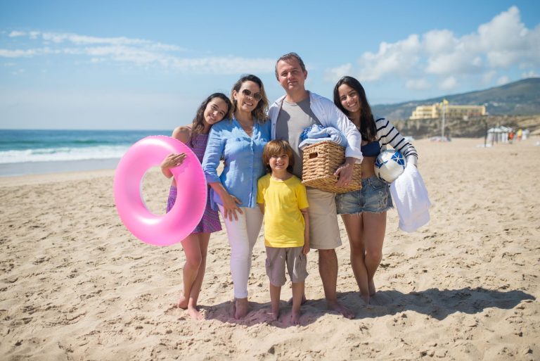 A cheerful family enjoying a sunny day at the beach in Portugal, capturing joyful moments together.