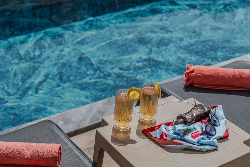 Enjoy chilled beverages by the poolside at a sunny resort, perfect for leisurely relaxation.