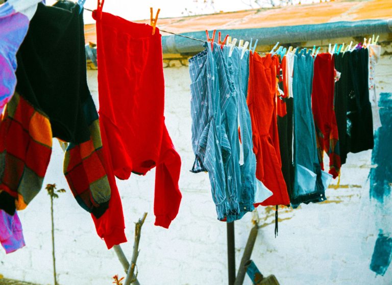 Colorful clothes drying on a clothesline under the sun, creating a lively outdoor scene.