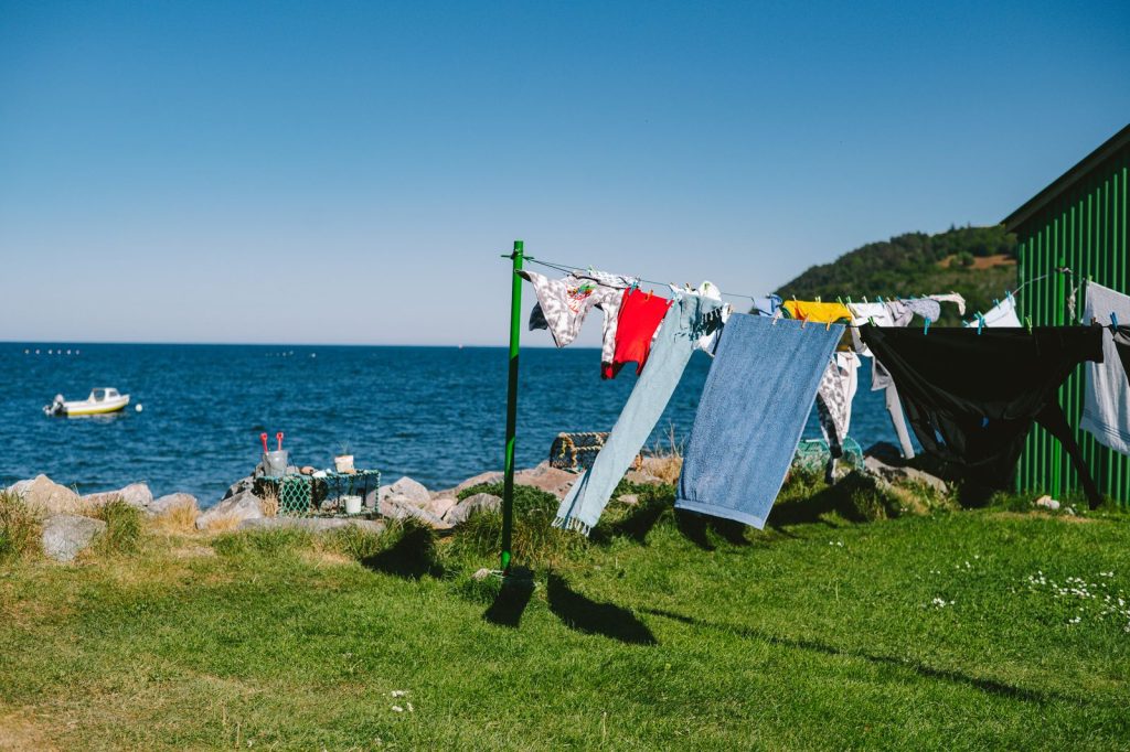 Vibrant laundry drying on a line by the sea in Avoch, Scotland, with a clear blue sky.