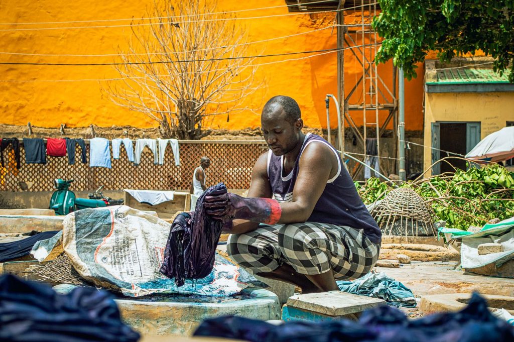 A man washes clothes outdoors, adding realism to a vibrant urban scene.