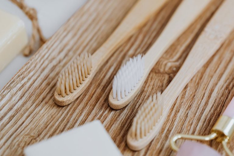 Close-up of eco-friendly wooden toothbrushes on a wooden tray, promoting sustainable oral care.
