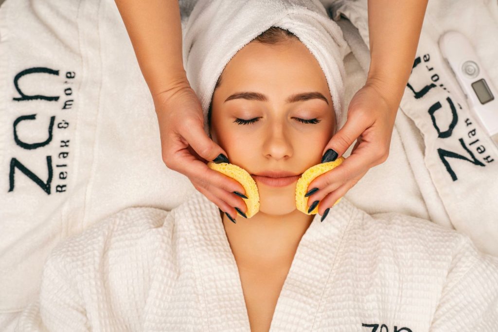 Woman receiving a soothing facial treatment in a spa setting, promoting wellness and relaxation.