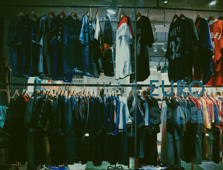 A variety of football jerseys on display in a Tokyo clothing store, highlighting a vibrant shopping scene.