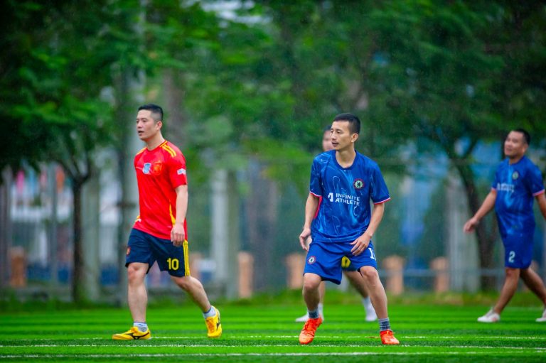 Amateur soccer players at a local field in Hanoi, Vietnam on a rainy day.