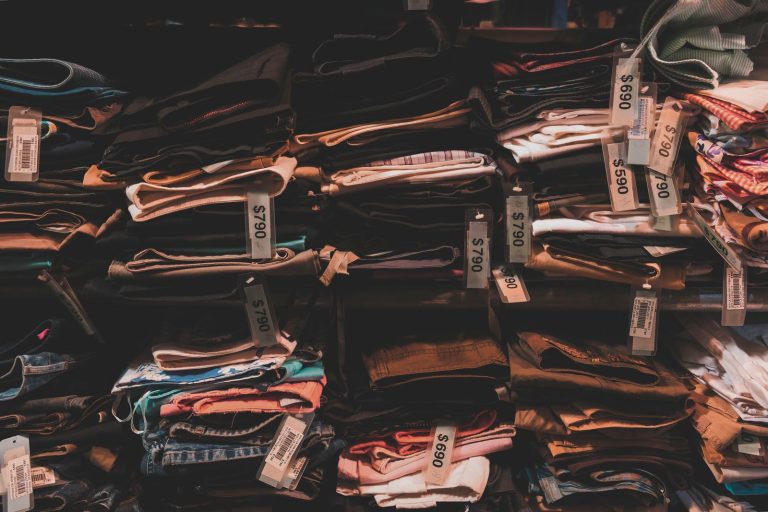 Neatly folded clothes with price tags on shelves in a Taipei shop.