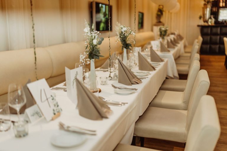 Beautifully decorated restaurant tables with floral arrangements, ready for a celebration.