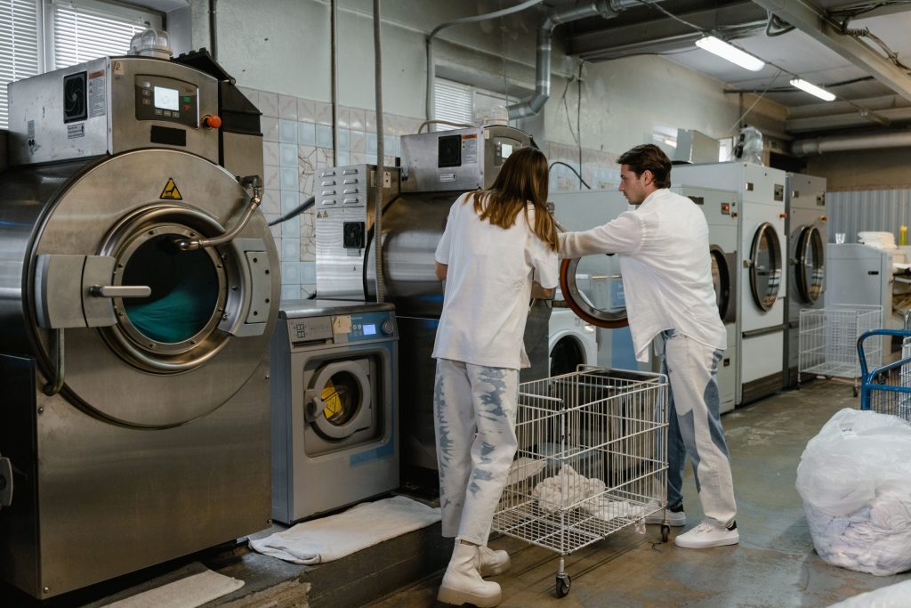 Professional laundry workers with industrial washing machines