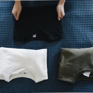 A person folding t shirts neatly