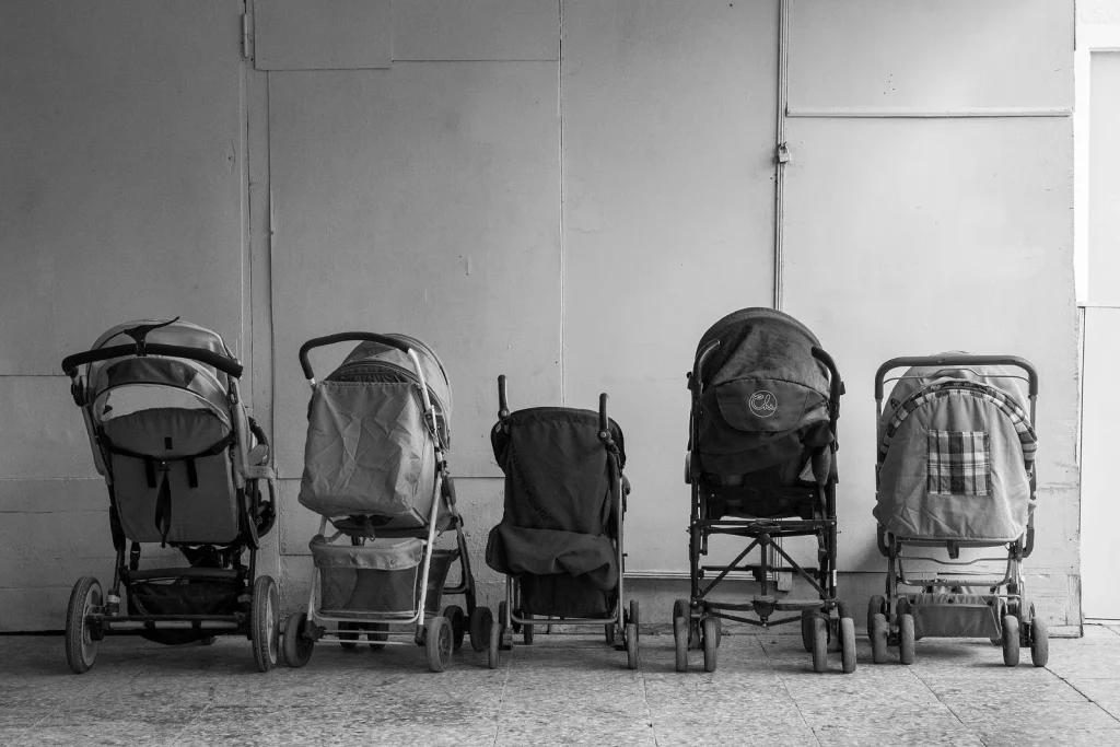 Row of baby carriages placed in hall of building