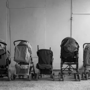 Row of baby carriages placed in hall of building
