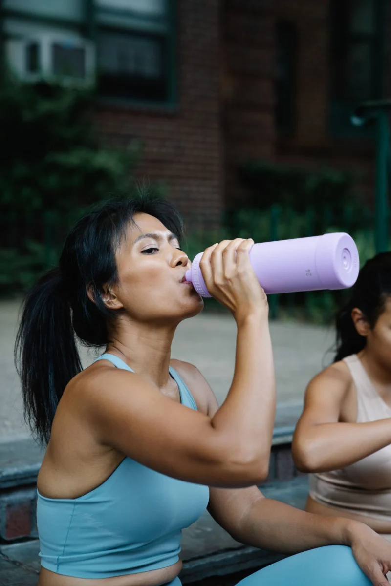 Woman drinking water after an outdoor workout