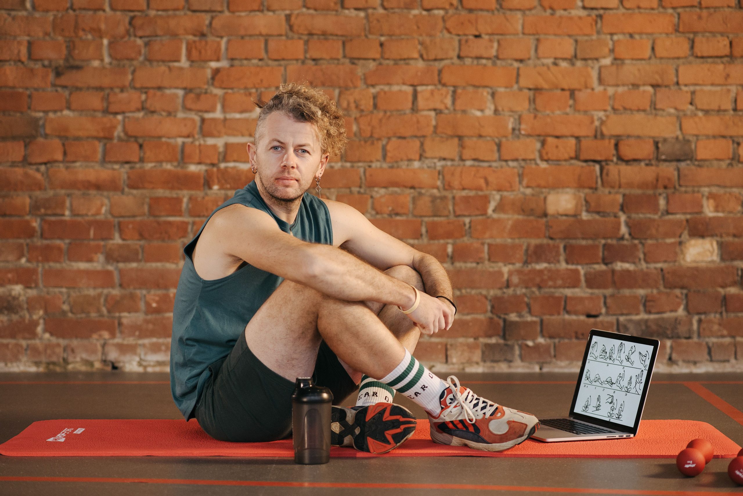Person using a laptop beside fitness equipment
